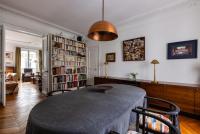 a living room with a table and bookshelves at Veeve - Artistic in Pigalle in Paris