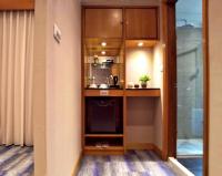 a small kitchen with wooden cabinets and a microwave at Beauty Hotels - Star Beauty Resort in Taipei