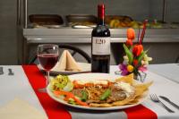 un plato de comida en una mesa con una botella de vino en Hotel Elizabeth Ciudad Deportiva, en Aguascalientes