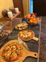 uma mesa com duas pizzas e uma tigela de frutas em Atrium Hotel Bucharest City Center em Bucareste