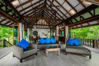 a living room with blue pillows on a porch at Koh Jum Beach Villas "A member of Secret Retreats" in Ko Jum