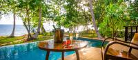 a table with drinks on it next to a pool at Koh Jum Beach Villas "A member of Secret Retreats" in Ko Jum