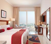 a hotel room with two beds and a large window at Treppan Hotel & Suites By Fakhruddin in Dubai