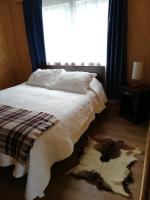 1 dormitorio con 1 cama con manta blanca y ventana en Puesto Cánogas, en Villa O&#39;Higgins