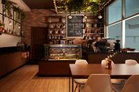 a restaurant with a bakery with a table and chairs at Treppan Hotel & Suites By Fakhruddin in Dubai