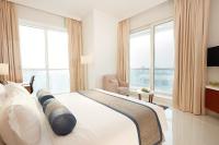 a bedroom with a large bed and large windows at Treppan Hotel & Suites By Fakhruddin in Dubai
