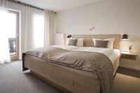 Un dormitorio con una cama grande y una ventana grande. en Bavaria Biohotel, en Garmisch-Partenkirchen