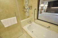 a bathroom with a shower and a sink and a mirror at Kindness Hotel-Qixian in Kaohsiung