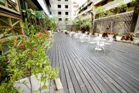 a deck with chairs and potted plants on a building at Kindness Hotel-Qixian in Kaohsiung