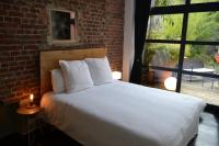 a bedroom with a bed and a brick wall at Chambre d&#39;hôtes la Teinturerie in Roubaix