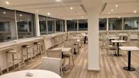 a restaurant with white tables and chairs and windows at Gran Hotel Fontainebleau in San Clemente del Tuyú