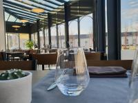 a wine glass sitting on a table in a restaurant at Hôtel de la Gare - Restaurant Bistro Quai in La Roche-sur-Yon