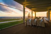 een eettafel op een terras met uitzicht op de oceaan bij Resort I Mulini in Trapani