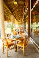 Un restaurante con mesas y sillas en un patio. en Hotel Villa Mercedes Palenque, en Palenque