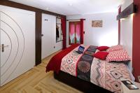 a bedroom with a bed with red pillows at Le Deroscope in Arrigny