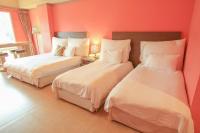 two beds in a room with red walls at Leofoo Resort Guanshi in Guanxi