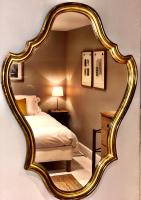 a bedroom with a large gold mirror on the wall at Maison Marie in Lagarde