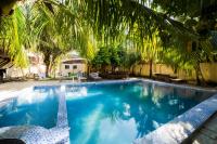 una gran piscina con una palmera en el techo en Antonio Garden Hotel, en Zanzíbar