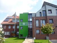 an apartment building with a green facade at Hotel &amp; Restaurant Pötter in Emsdetten