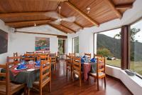 Un comedor con mesas y sillas y un gran ventanal. en El Crater, en San Antonio