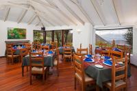 Un comedor con mesas y sillas y ventanas. en El Crater, en San Antonio