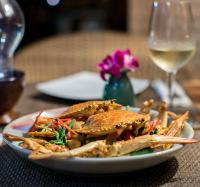 Haad Chao PhaoBeyond The Blue Horizon Boutique Bungalows的桌上的一小块食物,加上一杯葡萄酒