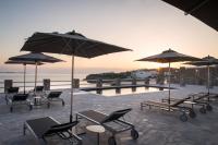 Un grupo de sillas y sombrillas junto a una piscina. en Alkistis Beach Hotel - Designed for Adults, en Agios Stefanos