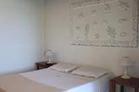 a bedroom with a bed with two tables and a picture on the wall at Pousada Casa do Catavento in Búzios