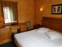 a bedroom with a bed and a dresser and a window at Hotel Manitoba in Blankenberge