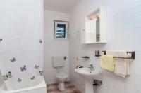 a white bathroom with a sink and a toilet at Apartmani Stjepan in Vinišće