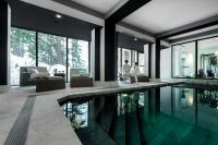 a swimming pool in a house with people in the background at Hôtel La Sivolière in Courchevel