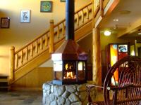 estufa de leña en una habitación con escalera en The Yukon Inn, en Whitehorse