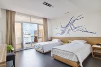 a hotel room with two beds and a window at Taitung Spring Homestay B&amp;B in Taitung City