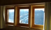 three windows in a room with a view of a mountain at Hotelski in Verbier