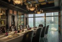 a long table in a room with a view of the water at Four Seasons Hotel Hong Kong in Hong Kong