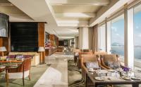 a restaurant with tables and chairs with a view of the ocean at Four Seasons Hotel Hong Kong in Hong Kong