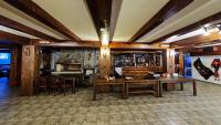 a living room with wooden tables and a bar at Hotel Dumanov in Bansko