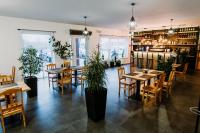 ein Restaurant mit Holztischen, Stühlen und Pflanzen in der Unterkunft GOŚCINIEC ZACISZE - pokoje & restauracja blisko A2 Dąbie - Uniejów in Dąbie