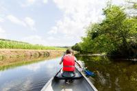 a person in a canoe on a river at Les Ecolodges de l&#39;Orbière in Forcé