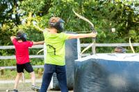 two young boys with helmets and shields playing with a bow and arrow at Les Ecolodges de l&#39;Orbière in Forcé