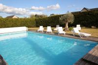 a swimming pool with lounge chairs and a swimming pool at Contemporary Villa of Kerseal in Gouesnach