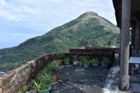a view of a mountain with potted plants on a wall at Shi-Jia B&amp;B in Jiufen