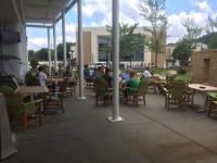 un groupe de personnes assises à des tables sur un patio dans l'établissement The Hotel Hot Springs, à Hot Springs