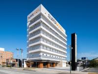 a tall white building with a sign on it at Super Hotel Yamagata Sakurambo-Higashine Station Front in Higashine