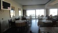 a dining room with tables and chairs and windows at Hotel O Mirandes in Miranda do Douro