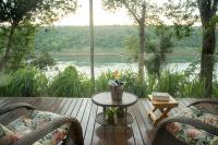 a patio with a table and chairs and a view of a river at Tupa Lodge in Puerto Iguazú