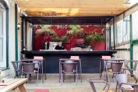 リスボンにあるIndependente Príncipe Realのテーブルと椅子とバーのあるレストラン