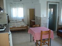 eine Küche mit einem Tisch und ein Zimmer mit einem Bett in der Unterkunft Katerina Apartments in Kokkíni Khánion