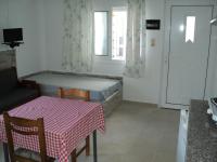 Zimmer mit einem Tisch und einem Bett sowie einem Tisch und Stühlen in der Unterkunft Katerina Apartments in Kokkíni Khánion