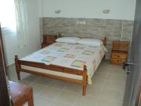 ein Schlafzimmer mit einem Bett mit einem Holzrahmen in der Unterkunft Katerina Apartments in Kokkíni Khánion